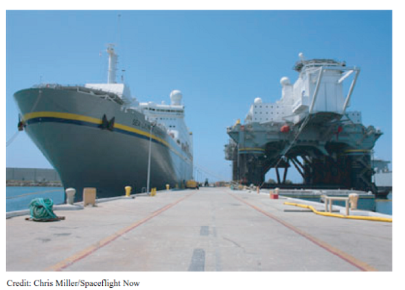 A Sea Launch Recovery  CIRCA 2008  Sea Launch engineers say the three-week round-trip journey across the Pacific Ocean is the most rewarding part of their jobs. The cruise is the culmination of nearly two months of work preparing the rocket, payload, and launch teams for the mission. Prior to operations at Home Port, about 18 months goes into the planning, flight design, and logistics. It's really nice to know most of the reviews are over and we're finally ready to launch, said Bill Rujevcan, mission director for the company's next flight. More than 300 people take the trip to the company's equatorial launch site about 1,400 miles south of Hawaii. The crew includes workers from several nations, including: Ukraine, Russia, Norway, the Philippines, and the United States. Ukraine-based Yuzhnoye and Yuzhmash build the Zenit 3SL rocket's first and second stages, while Energia of Russia manufactures the Block DM-SL upper stage for the rocket. Norwegian ship officers manage marine operations, and Filipino deckhands work on both the Sea Launch Commander and the Odyssey launch platform. U.S. employees from the Boeing Co. fill management roles and provide the flight design, payload fairing, and satellite adapter. Astrotech, a contractor, oversees processing of customer payloads inside a clean room at the company's Payload Processing Facility at Home Port in Long Beach, California. After 27 missions in nine years of business, Sea Launch is thriving in the do-or-die commercial launch industry. The company's Zenit 3SL rocket has suffered three setbacks in that time. Two were total failures. The rocket's success rate places it among the top tier of heavy-lift launchers on the commercial market, and the company's launch backlog seems to confirm that. Sea Launch is already booking payloads for launch in the future. Next year is sold out, according to company officials. Sea Launch Home Port is a decommissioned U.S. Navy facility on the tip of a manmade peninsula at the Port of Long Beach. The Sea Launch buildings are all left over from the Navy except for the Payload Processing Facility, which the company built in the late 1990s. The company's pier is home to two one-of-a-kind vessels-the Sea Launch Commander and the Odyssey launch platform. The Sea Launch Commander carries about 240 people, ranging from rocket technicians and corporate leaders to chefs and helicopter pilots. The Commander houses a state-of-the-art launch control center divided between two sections designed for Ukrainian and Russian engineers and American engineers and managers. The cavernous rocket assembly and checkout hall is located on the command ship's lower deck and stretches nearly the entire length of the vessel. The facility is capable of supporting two simultaneous launch campaigns using staging and integration compartments and a fueling cell. Giant cranes inside the high bays lift rocket stages, which sits on Russian-gauge rails on the floor integration room floor. The rocket's ground support equipment inside the Sea Launch Commander is virtually identical to hardware used for Zenit launches at the Baikonur Cosmodrome in Kazakhstan, according to Sea Launch officials. The Sea Launch Commander was specially constructed for Sea Launch at a Scotland shipyard by the maritime unit of Kvaerner, then a leading Norwegian industrial company. Measuring 656 feet long and 105 feet wide, the command ship was outfitted with more than 600 tons of rocket support equipment in Russia before sailing to Long Beach in 1998. The massive ship's crew quarters are home to Sea Launch's international employees during their stay in the United States. The Sea Launch Commander and the Odyssey platform are seen here docked at Home Port.     As Ukrainian and Russian engineers complete work to ready the Zenit rocket, technicians inside Sea Launch's Payload Processing Facility are busy preparing the booster's satellite payload down the road from the docked vessels. When both groups are ready, the spacecraft is transported about 1,000 feet and loaded into the Sea Launch Commander's final assembly hall on the roll-on, roll-off vessel. Already enclosed in the payload fairing, the satellite is attached to the Zenit-3SL's upper stage to complete the rocket's construction. EchoStar 11, the payload for Sea Launch's mission this month, was rolled from the clean room to the command ship hangar June 25. The 12,150-pound satellite was bolted to the Block DM-SL upper stage a day later. The rocket was next moved to the Odyssey Launch Platform. The launcher, which weighs about 100,000 pounds without propellant, is transferred in a high- precision operation more 200 feet above the waters of Long Beach Harbor. The Sea Launch Commander first pulls in front of Odyssey and the rocket is rolled out of the integration hall. The rocket is then hoisted into Odyssey's hangar, where it stays during the transit from Long Beach to the launch site. Sea Launch then lifts the 200-foot-tall rocket upright on its launch pad for a final series of tests to make sure all systems are ready to set sail for the equator. That's our last big test before we leave, Rujevcan said. Odyssey, the slower of the company's two ships, usually leaves Long Beach a few days before the Sea Launch Commander. The launch platform left port for the EchoStar 11 campaign last week. With a top speed of about 12 knots, Odyssey's crew of 70 sailors and engineers serve as caretakers of the Zenit rocket during the 2,882-mile transit to the launch site along the equator at 154 degrees west longitude. Odyssey is a converted North Sea oil drilling platform built in Japan in 1983. Kvaerner's maritime division modified the vessel between 1995 and 1997 to support rocket launches, according to Sea Launch. The changes included adding two extra vertical support columns, effectively extending the length of the platform to 436 feet. The deck extension was needed to make room for the Zenit launch pad, an immense hole in Odyssey's deck with a gas diffuser directly beneath it, said Paula Korn, Sea Launch spokesperson. Workers replaced more than 20 miles of wiring on Odyssey after Sea Launch suffered a failure on the launch pad during a liftoff last year. The platform underwent a slate of repairs, including the replacement of a destroyed gas deflector and the repainting of the ship, Korn said. The Sea Launch Commander pulled out of port this weekend to begin its trek to the equatorial Pacific. The ship will rendezvous with Odyssey at sea later this week. Officials keep busy during the trip by completing a handful of final prelaunch reviews, two countdown rehearsals and several other meetings, Rujevcan said. The ships also offer a number of recreational activities for the launch team. The Sea Launch Commander carries basketball and volleyball courts, a swimming pool, and a movie theater, not to mention opportunities to play pool, foosball and air hockey. Crews also enjoy access to DirecTV programming and XM Satellite Radio, two regular customers for Sea Launch. The Sea Launch Commander is furnished with a full-service cafeteria and bar, but the booze stops flowing soon after the ships arrive at the launch site. Odyssey's ballast tanks are filled with seawater to submerge the platform's pontoons to a depth of about 65 feet to help keep the vessel stable. The command ship pulls alongside Odyssey and technicians move between the vessels using a 115-foot-long link bridge. The team begins the launch countdown three days prior to liftoff. The Sea Launch Commander sails three-and-a-half miles away from Odyssey a day before launch. A helicopter transfers final personnel and equipment between the vessels. The Zenit 3SL rocket is rolled out of its hangar and erected on the pad about 27 hours before the scheduled launch. Pneumatic pistons power the erector during the 10-minute lifting operation, and technicians torque four hold-down bolts to firmly attach the rocket to the launch pad. The bolts automatically retract from the booster at liftoff. The countdown enters an automated sequence five hours before launch, and the team serves as watchdogs to ensure no preset parameters are breached. The final workers are evacuated from Odyssey about three hours prior to launch. During the final countdown, Odyssey's marine crew occupies a remote control station on the bridge of the Sea Launch Commander. The consoles give the marine officers full control of the launch platform three-and-a-half miles away. Fueling of the Zenit 3SL's three stages with kerosene and liquid oxygen begins two hours and 40 minutes before liftoff. Fuel and oxidizer tanks aboard Odyssey hold enough propellant for three launch attempts, according to Rujevcan. Managers hold their final poll 36 minutes before launch, and the rocket's umbilical arm detaches from the rocket at the 17-minute point. The Zenit's automated sequence reaches a last milestone with one minute to go. At that point, we are committed to launch unless the sequence tells us to stop, Rujevcan said. Now on his 18th mission to the equator, Rujevcan is one of three certified Sea Launch mission directors. The mission director is the final authority on whether the launch occurs. I am the ultimate go guy, he said. Rujevcan oversees a team of about 50 engineers inside the Launch Control Center. The launch team typically conducts three launch rehearsals during each campaign to hone their skills. The launch team monitors the rocket, weather, ship systems, and ground stations to ensure they are all ready for launch. Notices of the launch are issued for vessels traveling in the area to keep at least 25 miles from Odyssey during the final countdown. Sea Launch helicopters and ship-based radar. Officials closely watch Odyssey's exact location during the final moments before launch. Managers allow a tolerance of two kilometers, or about 1.2 miles, from the standard launch site at the intersection of the equator and 154 degrees west longitude. Powerful underwater azimuth thrusters hold Odyssey's heading at launch time. The platform must be within one degree of the expected orientation for launch. A Sea Launch campaign in November was plagued by persistent strong ocean currents and high winds. The underwater thrusters were not enough to match the unruly conditions, and the platform constantly drifted out of position. Officials eventually ordered the ships to return to California after more than two weeks on station at the mid-Pacific launch site. Engineers have since installed extra generators on Odyssey to increase the amount of time the vessel can stay at sea. The unusual experience with ocean currents is an example of how Sea Launch continues to encounter challenges and learn from experience, Korn said. Rujevcan agreed. After 27 missions, you just see a little bit of everything, Rujevcan said. It's never really routine to the point of complacency. CIRCA 2009, HOW FAST THINGS CAN CHANGE!  Sea Launch's bankruptcy filing this week was brought on by recurring financial losses, partially stemming from a 2007 rocket failure that helped set off a cascading series of delays and customer defections, according to court records. A file image shows a Zenit rocket on the Odyssey floating pad ready for flight and the Commander ship overseeing the countdown nearby.     The launch services provider and five affiliated businesses filed for Chapter 11 Bankruptcy protection in a Delaware court. In the filing, the company said it is unable to repay debt or secure new financing, making bankruptcy reorganization the best avenue to keep the company afloat. Officials say they intend to continue normal business operations, including the pursuit of new launch contracts to bring in new revenue. Whether satellite operators will sign with a company in bankruptcy remains to be seen, but Sea Launch leaders attempted to ease their concerns. We want to assure our customers, employees, suppliers and partners that Sea Launch intends to continue to operate after the filing, said Kjell Karlsen, president and general manager of Sea Launch. Chapter 11 reorganization provides an opportunity for us to continue operations and focus on building our future plans. We are grateful for the continued support of our customers and partners while we focus on reorganizing for the future. Two more launches had been planned for 2009. Sea Launch has contracts for 10 launches through 2012, officials said. Sea Launch reported assets between $100 million and $500 million and estimated debt of almost $2 billion. The company will explore the potential sale of one or more of its business units during the bankruptcy proceedings, officials said. The company has long been on shaky financial ground and has struggled to recognize the success envisioned when it was formed in 1995, according to the filing. Officials blamed the weak commercial launch industry, skyrocketing hardware costs, the credit crunch, and intense competition from other launch providers for being unable to stabilize their business or meet their financial targets, according to a declaration by Brett Carman, Sea Launch's vice president and chief financial officer. Carman cited Sea Launch's government-backed competitors in Europe and Russia, which snatched commercial satellites left stranded on the ground following a dramatic launch failure in January 2007. That accident destroyed the Zenit 3SL rocket and a Dutch telecommunications satellite before they even left the launch pad. The massive explosion also damaged the company's Odyssey launch platform and grounded the Zenit rocket for nearly one year. Sea Launch has completed nine launches since returning to flight in January 2008, including six missions staged from sea and three flights under the company's Land Launch subsidiary. But the delays caused several customers to move their launches to Arianespace and International Launch Services, Sea Launch's primary competitors, to ensure their satellites could be sent into orbit on time. Arianespace offers dual-payload launches on its Ariane 5 rocket, while ILS uses the venerable Russian Proton booster launched from the Baikonur Cosmodrome in Kazakhstan. The impact from the failure was largely focused on lost schedule time, said Paula Korn, a Sea Launch spokesperson. While we were able to reschedule some of our customers' missions, a few missions were reassigned or moved off the Sea Launch system to other launch providers. One customer, Hughes Network Systems, moved their satellite to an Ariane 5 rocket a month after the mishap. Hughes also filed a claim for a $44.4 million reimbursement for advance payments the satellite operator had already paid Sea Launch. After Sea Launch contested the claim, an arbitration decision earlier this year ruled in favor of Hughes, saying the launch provider had to pay the advance payments plus interest, an amount totaling $52.3 million. A standstill agreement brokered in March between Sea Launch and Hughes later expired, and Hughes filed another petition earlier this month to recoup the money. The parties could not reach a payment agreement by the June 22 deadline, the same day Sea Launch filed its Chapter 11 petition. In a written response to questions, Korn said delays in the delivery of crucial rocket equipment caused further delays, exacerbating Sea Launch's financial problems. The missed delivery milestones were blamed partly on the world's financial crisis. The late deliveries also made it more difficult for Sea Launch to meet its customers' schedule requirements, causing more payloads to jump to other rockets. Sea Launch has lost three more payloads so far this year to the Proton rocket, according to an ILS statement last week. Carman's declaration also detailed debts owed Sea Launch's investors and creditors, including $119 million in cost overruns still unpaid from the company's early development work in the late 1990s. Sea Launch is owned by corporate shareholders in the United States, Russia, Norway, and Ukraine. Boeing Co. holds a 40 percent stake in the partnership, providing support services and hardware for the Zenit rocket's payload unit. Sea Launch owes Boeing nearly $1 billion in loans, trade debt, and partner liabilities, according to the bankruptcy filing. Russia-based Energia, which holds a 25 percent interest, builds the rocket's Block DM-SL upper stage and supports launch vehicle integration and mission operations. Aker, a Norwegian shipbuilder, constructed the company's command ship and launch platform and owns 20 percent of the company. Ukrainian rocket manufacturers Yuzhnye and Yuzhnoye control a 15 percent share of Sea Launch. Sea Launch owes more than $1.5 billion to its investors, according to figures provided in court documents. The rest of its debt is in bank loans. The company stopped paying its suppliers as its financial health slipped, according to Monday's filing. Boeing and the other Sea Launch partners support Sea Launch's effort to explore restructuring alternatives through an orderly bankruptcy court process, Boeing said in a written statement. Sea Launch and its Land Launch division have carried out 33 missions since 1999. Thirty of those launches were deemed total successes. We are hoping to get back on our feet and move forward, doing what we do best, putting our customers' satellites in orbit, Korn said. CIRCA 2010  Launch services provider Sea Launch Co. is in advanced negotiations with two potential strategic investors and expects to emerge from Chapter 11 bankruptcy proceedings by midyear and to return to operations in 2011, Sea Launch President Kjell Karlsen said. Karlsen declined to name one of the investors. The other is Space Launch Services, created by Excalibur Almaz, a company founded to launch astronauts into orbit to stay at a space station based on existing Russian hardware. The company also has been looking at making the Russian-Ukrainian Zenit launch system capable of launching astronauts. Sea Launch uses the Zenit rocket to launch satellites. It's a tough market, that's for certain, and there aren't a lot of Elon Musks around, Karlsen said, referring to the Internet entrepreneur who has devoted much of his fortune to starting the rocket-launch company Space Exploration Technologies. Space Launch Services has been providing Sea Launch with sufficient cash to carry it through Chapter 11 but has not yet confirmed whether it has the will or the resources to operate Sea Launch as a business. Space Launch Services officials, attending the March 3 World Space Risk Forum in Dubai, said one option they are considering is whether to relocate the Sea Launch ocean-launch platform closer to U.S. territory. A launch from U.S. territorial waters would have the dual advantage of reducing the time and expense of positioning the floating launch platform in the Pacific Ocean on the equator, and increasing the possibility that Sea Launch could qualify as a U.S. launch system and thereby compete for U.S. civil government launch contracts. In an interview, Karlsen said that post-Chapter 11, a Sea Launch operation freed from its debt service could be operated for about $50 million per year. The biggest cost is the Sea Launch Commander control ship, which accompanies the Odyssey launch platform to and from the launch site. Sea Launch lost money every year since its first flight in 1999 and accumulated some $1.4 billion in losses before filing for protection under Chapter 11 of the U.S. bankruptcy code in mid-2009. Karlsen said Sea Launch has three contracts-one from Intelsat of Washington and Luxembourg, and two from Paris-based Eutelsat-on its books. Refurbishing the launch platform and the command ship after months of inactivity would not be expensive, he said, and the commercial launch market-in the form of satellite fleet operator support for Sea Launch-appears to want Sea Launch back in business. Sea Launch's investors, led by Boeing, which had a 40 percent equity stake in the company, are now involved in the Chapter 11 bankruptcy court proceedings in Delaware, their lawyers hoping to salvage at least part of these companies' investment. Boeing also is seeking reimbursement from Sea Launch's Russian and Ukrainian partners for Boeing loans made on behalf of the company. Karlsen said that when it comes to a decision point, Boeing, Aker of Norway, and RSC Energia of Russia and Yuzhnoye of Ukraine will agree it is in their interests to have Sea Launch return to flight, even if it means abandoning hope of recouping their investment. The alternative-a Chapter 7 liquidation of Sea Launch's assets-would fetch between $100 million and $130 million, Karlsen said. 2010, INDIA UPS THE ANTE  India plans to cut satellite launch cost by half with the heavy-lift rocket that it is developing, a senior space department official said. The country is also aiming a two-to-three fold increase in the number of spacecraft launches from this year, Chairman of Indian Space Research Organisation K Radhakrishnan said. GSLV-Mk III that ISRO is developing now would bring down the satellite launch cost at least by half, at present, the launch cost is pegged at around USD 20,000 per kilogram, he said. GSLV-Mk III, which would have the capability to launch satellites of four tonne class, nearly twice the mass that ISRO can currently carry to space, is expected to be operational in next two-three years. Delivering the inaugural lecture of IIScAA (Indian Institute of Science Alumni Association), he said India currently has 211 communication transponders, including 195 operational. Go to www.space.com/missionlaunches/2010-launch-log.html and review the history of space launches toward forecasting demand for Sea Launch's services for the next five years.