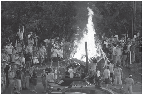 Caught in the War Zone  MIKE GRUNDMANN AND ROGER SOENKSEN James Madison University  War Zone blared the giant headline above photos of fire, vandalism and drunken students being arrested by police in riot gear. This was an out-of-control Springfest, the annual pre-finals block party at James Madison University in Virginia. The Virginia event is but one rite of spring held on college campuses across the nation. Iowa State calls it Veishea and that event has turned ugly more than once over the years. At the University of Colorado's similar event, more than 10,000 people show up to smoke pot. By 2010, on the campus of the University of Virginia, Springfest had ballooned thanks to notices on Facebook that drew students and nonstudents from other states. The 2010 number, estimated to be about 8,000, was about four times larger than previous years according to the Post, and the block party began to get out of control. Two photographers for The Breeze, the twice-weekly student newspaper, had taken hundreds of photos of the event and continued as the crowd grew more unruly, spilling into a nearby neighborhood. According to the Post, President Linwood H. Rose e-mailed the entire 18,500 student campus the following Sunday. Your collective behavior was an embarrassment to your university and a discredit to our reputation, he wrote. No one is opposed to some fun on a beautiful spring weekend, but public drunkenness, destruction of property, and threats to personal safety are unacceptable outcomes. Five days after the melee, the chief local prosecutor, Marsha Garst, was pursuing claims that both attendees and police as well had been assaulted. In trying to find the perpetrators who might have escaped the police dragnet, Garst's office asked The Breeze editor, Katie Thisdell, and a faculty adviser to turn over any unpublished photos so offenders could be identified and arrested. Both refused, on grounds that the paper could not make itself an arm of the law and must remain independent. The next day, Garst, joined by the campus police chief and other law officers, raided the newsroom with a search warrant. It demanded all Springfest photos under threat of confiscating all computers, cameras, cellphones and other devices that could contain the photos. The number of photos seized in this manner was more than 900, according to the Washington Post.  Acting on the advice of the Student Press Law Center (SPLC), Thisdell refused, citing the federal Privacy Protection Act (PPA), which shields newspapers from such seizures until they can be challenged in court. The PPA was passed in 1980 just after the state of California had successfully pursued a newsroom search and seizure over the objection of the editors. Interestingly, this case, too, also sprang from a college campus-Stanford University, where the students had photos of ariot on campus and had refused to turn them over. However, this congressional action did not sway Garst, who stuck to her ultimatum. Thisdell, who considered a newsroom emptied of its tools an unacceptable option, relented and turned over all the photos. Thisdell and her advisers alerted news media in the region, and the story went national, including a Washington Post editorial condemning Garst. The Breeze also provided continuous coverage of its own story, but not using any of the staffers directly involved. The state attorney general, Ken Cuccinelli, at a speaking engagement in town, was asked his opinion of Garst's actions. He supported them. A lawyer provided free by the SPLC finally convinced Garst of the Privacy Protection Act's provisions and persuaded her to surrender the photos to a neutral third party so negotiations over the next step could begin. The lawyer advised Thisdell: You can stand by your principle and refuse to turn over any of the photos, but with a plurality of conservative judges, there was a risk of a court order essentially matching the search warrant. Or you can negotiate with Garst to turn over the few photos that show suspects Garst is after. Thisdell, her advisers and her photographers considered the consequences of both choices. Refusing could mean a newsroom shutdown, public accusations of shielding criminals, and weeks, months or years of court appearances. Compromising could embolden future prosecutors, harm The Breeze 's journalistic reputation and discourage important future sources. Thisdell decided to compromise and ultimately turned over 20 photos. As part of the bargain, The Breeze won a public apology from Garst, who said she regretted frightening the student journalists and would follow the law next time.     Rober Boag, The Breeze      Rober Boag, The Breeze  If the public accuses your news organization of shielding criminals, is that a price worth paying for sticking to the journalistic principle of independence?
