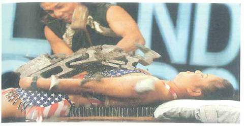 Figure shows a famous bed of nails trick. The woman lies on a bed of nails with a cinder block on her chest. A person hits the anvil with a sledgehammer. The nails do not pierce the woman's skin. Explain why.     FIGURE A bed of nails See Conceptual Question.