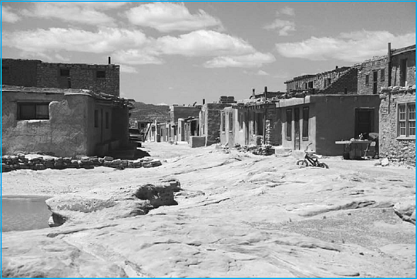 Impacts of a Cultural Ecology: Historical Trauma, American Indians/Alaska Natives, and Health  The concept of historical trauma has been used in recent years in reference to the health and social effects of long-term population level violence experienced by an entire people as a result of colonialism, slavery, genocide, and other profound historical circumstances. The result of these experiences is often marginalization, poverty, and poor health for these peoples within the context of a broader political-economic system of which they are a part. The social ecology we are talking about, then, involves the relationship between a given population group and the society that structures that historical trauma experience. Cultural patterns related to health for that group evolve out of that relationship, as a process of coping over time (see Starfield 2007; Edberg, Cleary Vyas 2010). While historical trauma has also been used regarding Holocaust victims, Japanese survivors of World War II internment camps, and to some extent African Americans, it has most often been used in connection to health issues among American Indian/Alaska native populations in the United States. The use of historical trauma in this sense has primarily referred to the American Indian experience of chronic, intergenerational trauma and unresolved grief spanning generations, resulting from the genocidal loss of lives, land, and culture from European contact and colonialism (Brave Heart DeBruyn 1998; Brave Heart-Jordan 1995). As noted earlier (in Chapter 4), historical trauma has poignantly been referred to as a soul wound (Duran, Duran, Yellow Horse Brave Heart 1999). Here is a brief list of key points in that history that relate to the historical trauma experience: • When the Europeans arrived, there were significant populations of American Indians/Alaska Natives in North America-estimates vary widely, but anywhere from just under 1 million to over 12 million (Lord 1997). Figure 1 World War II Japanese Camp     • The native population of the Americas had been there since approximately 12,000 BCE (specific estimates vary on this date), when successive waves of Eurasians came to what is now the United States across the Bering land bridge between Siberia and Alaska called Beringia (now submerged, as the Bering Strait) and expanded throughout North and South America, creating everything from hunter-gatherer societies to the more complex Iroquois and Anasazi (Pueblo) in the United States and the Olmec, Aztec, Maya, and Inca in Central and South America. • Early on, the relationship between the expanding colonial society in North America and Indian peoples was complex, sometimes involving alliances and collaboration, sometimes involving forced dislocation, conflict, and violence. Indian peoples were, however, typically viewed as uncivilized and subordinate in character to Europeans, and the power of European weaponry enforced an emerging social hierarchy. In addition, native peoples were decimated by diseases such as smallpox brought over from Europe. Figure 2 Carlisle Indian School (Boarding School)     • With American independence and rapid population growth, the new country began to expand westward, heightening conflicts over land. In 1830, the Indian Removal Act was passed, authorizing the removal of Indian peoples in the Southeastern states and territories to make way for settlers. This was the setting for the infamous Trail of Tears (Carter 1976), in which some 17,000 Cherokee left or were removed from their homes and 4,000 died during the forced relocation to what is now Oklahoma. • As settlers moved into the Great Plains and western United States, they met with increased resistance, and there followed a long and violent period of Indian wars between settlers or the U.S. army and Indian peoples. These conflicts became increasingly brutal, and the army's mission focused on the extermination of Indians who did not surrender and resettle in designated reservations. On these reservations, the land was generally poor, and it was difficult to make a living. Figure 3 Indian Reservation, Southwest U.S.     • Following the wars, boarding schools were established with the aim of civilizing and acculturating Indian children by forbidding the practice of their indigenous cultures and religions, prohibiting the use of Indian languages, and often seeking to convert the children to Christianity. Attendance at these boarding schools was common throughout even much of the 20th century, with peak levels in the 1970s. The experience was widely viewed as traumatic. • Over time, much of the land held by American Indians was appropriated by force or by violating treaties (some was also sold), resulting in the continued loss of both economic and cultural/religious resources. Only in recent years have a number of tribes sued for the return of their lands and been able to control and exploit the resources available to them. What Is Anomie?  A sociological term popularized (but not originated) by sociologist Emile Durkheim. According to the Random House Dictionary (at www.dictionary.com): A state or condition of individuals or society characterized by a breakdown or absence of social norms and values, as in the case of uprooted people. As a result of the long historical experience of colonization, appropriation, cultural suppression, violence, and marginalization, the current situation includes poverty rates twice that of the U.S. population as a whole (U.S. Census Bureau's American Community Survey from 2007 to 2009), and even higher rates for some tribes such as the Sioux, Navajo, and Apache. Factors related to historical trauma have been associated with a range of social pathologies and negative health/mental health outcomes among American Indians and Alaska Natives (see Struthers and Lowe 2003), such as: • A high prevalence of cardiovascular disease risk factors such as cigarette smoking and hypertension among American Indians and Alaska Natives, for example, has been related to perceived discrimination and its effects (Krieger, 2000; Johansson, Jacobsen, Buchwald, 2006). • Studies have reported strong associations between perceived discrimination and increased depressive symptoms in adult American Indians in the upper Midwest (Whitbeck et al. 2002). • Loss of self-esteem, depression, poverty, and loss of traditional male roles have been cited as additional factors related to cardiovascular disease (Rhoades 2003). • Health risk behavior among male American Indians and Alaska Natives may be due to a loss of traditional male roles (Oetting et al. 1998), unresolved grief from historical trauma (Brave Heart DeBruyn, 1998), and particularly among younger men, anomie and a loss of cultural identity (O'Nell Mitchell, 1996). Studies suggest that there is a range of phenomena that may form part of an overall historical trauma syndrome that in turn is associated with numerous health conditions. How does that happen? Whitbeck et al. (2004) made an important contribution by attempting to disentangle the mechanisms through which historical trauma affects American Indians and Alaska Natives. Because the experience was often voiced in terms of loss, this important research sought to identify the kinds of losses and resulting emotions associated with historical trauma. Identified losses were converted to items on an historical loss scale and included: • Loss of land, language, culture, and traditional spiritual ways • Loss of family ties because of boarding schools; loss of families due to government relocation • Loss of self-respect due to poor treatment by government officials • Loss of trust in whites from broken treaties • Losses from the effects of alcohol • Loss of respect for elders • Loss of people through early death • Loss of respect by children for traditional ways Figure 4 Historical Trauma Model     Emotions (symptoms) produced by these losses were then converted to items on an historical loss associated symptoms scale. These included: • Sadness, depression • Anger, rage • Anxiety/nervousness • Being uncomfortable around white people when thinking of these losses • Shame when thinking of these losses • Loss of concentration • Feeling isolated or distant from other people when thinking of these losses • Loss of sleep • Fearful or distrust concerning the intentions of white people • Feeling like the loss is happening again • Feeling like avoiding people or places that are reminders of the losses High loss scores were significantly associated with clusters of emotional symptoms. In another significant effort to understand the phenomenon, Evans-Campbell (2008) proposed a multilevel framework for studying the impacts of historical trauma at three levels: individual, family, and community. 1. Individual impacts include symptoms characteristic of posttraumatic stress disorder, guilt, anxiety, grief, depression, and other symptoms. 2. At the family level, impacts may include impaired family communication and parenting stress. 3. Community -level impacts are said to include breakdown of traditional culture and values, loss of traditional rites of passage, alcoholism, physical illness, and internalized racism. Evans-Campbell also highlighted two key issues regarding historical trauma, as opposed to other kinds of trauma: (1) it is a collective phenomenon, something that happens to a community or a people; and (2) it does not refer to just any kind of trauma, but trauma perpetrated by outsiders with purposeful and often destructive intent (ibid., pp. 321). These are both significant efforts to identify the specific nature and inherent mechanisms of historical trauma as a politicaleconomic and cultural phenomenon. At the same time, it may be limiting to confine the historical trauma triggers to individual experience with actual land loss, disruption in family systems as a secondary impact, or even loss of specific cultural practices, for example. Many American Indians/Alaska Natives (younger adults, youth) no longer think actively about land loss, the impact of specific historical events, or traditional culture loss. Yet they experience similar/related emotional symptom clusters as do those who attribute their emotions to those issues. It is possible that historical trauma exerts its effect as a broader, socially shared and cross-generational phenomenon, and that to fully understand and address it will require more examination of mediating mechanisms, the ways in which it influences individual interpretation of events, and other indirect impacts. All of this suggests that an important dimension of the experience called historical trauma lies in the way people link their own self-image to their perceived social status, in contrast to other segments of society that were once the perpetrators of their historical experience. The self-image aspect refers to identification as a member of an historically oppressed group, and a general, perceived loss of power, control and status. So it isn't just the loss, but the meaning of that loss (what it represents), which in turn has a broad impact on collective, shared psychological experiences of a people. In 1969, the anthropologist Anthony Wallace, in his work on cultural destruction and revitalization (much of it focusing on the Iroquois people), described cultural traumas as externally induced stress on the mazeway-a mental image people maintain about themselves and their society (Wallace 1969; 1956). Such severe mazeway stressors can result in sociocultural breakdown progressing through various stages, in which cultural well-being and efficacy-the positive, predictive value of culture-is reduced or lost, followed by psychological consequences such as anomie, anxiety, frustration, increased sociopathy. Wallace called these psychodynamically regressive responses. While his research occurred some time ago, his general description remains very relevant to the nature of historical trauma. Historical trauma-related cultural beliefs people share about patterns of limitation or negative probability regarding the future, are often played out in day-to-day lived experiences that reinforce the model-e.g., poor health, discrimination, other negative occurrences-as well as the general content of people's conversations and explanations concerning why things are the way they are. So, in response to negative health and social circumstances, Mashpee Wampanoag (a Massachusetts tribe) men say, Well, that's just part of Mashpee (Johansson Doherty 2001). What are some political-economic circumstances that could impede people from engaging in exercise as prevention for diabetes and cardiovascular disease?