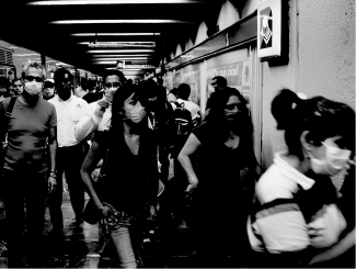 What aspect of the germ theory of disease has influenced the behavior of most of the individuals in the picture below?   A)Coughing in a public place is socially unacceptable. B)Disease-causing pathogens are communicable; they can spread from an infected individual to an uninfected individual. C)Medications like antibiotics are a selection mechanism that ultimately strengthens the disease. D)The pathogens that cause disease are too small to be seen without a microscope.