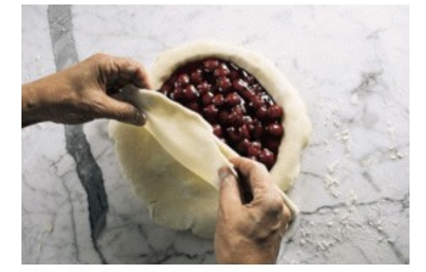    The bottom crust of the filled fruit pie pictured is made from a flaky pie dough.