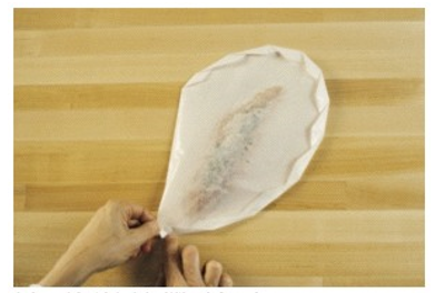 In the picture, the fish is being prepared by what method of cooking?    A)  En papillote B)  Marinière C)  à l'Americaine D)  Grenabloise