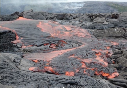   The streamlined ropy flowing lava pictured here has both orange and black parts because . A)  the black part is aa, while the orange is pahoehoe B)  the top of the lava flow cools slower than the middle of the lava flow C)  orange represents the cooler parts, which are below the surface D)  the surface cools faster than the lava below, and is black in appearance 
