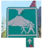 In this figure the sign shows:   A)  the direction towards the volcano. B)  the route for evacuation. C)  the direction parents should take their kids towards the active volcano site. D)  that the volcano is active,so please follow the route. E)  both the route for evacuation and that the volcano is active.