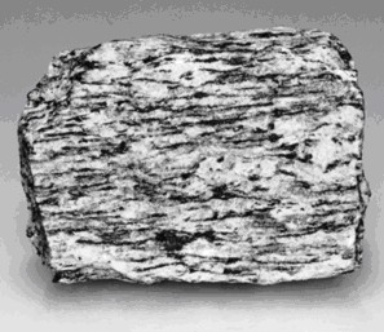 Carefully examine the photograph below of a metamorphic rock sample.The sample is shown as its actual size.     a)Is this rock foliated or nonfoliated? ________ b)What is the name of this metamorphic rock? ________ c)Consider how this rock got its texture.Was is compressed from top to bottom or from side to side? ________