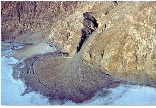   Which landform results from water exiting a constricted channel and losing velocity? A) Meander scar. B) Delta. C) Alluvial terrace. D) Alluvial fan.