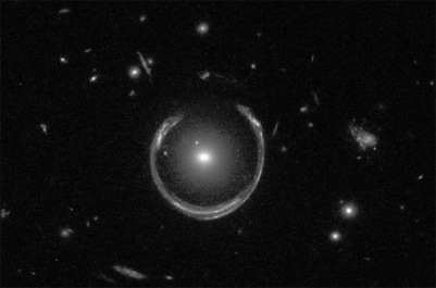 Two galaxies are shown in the image below.The central,nearly round object is nearby,while the ring-like object is actually positioned immediately behind the central galaxy.Why do we perceive the latter as a ring?   