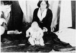What is going on in this famous photo?   A) Edward Thorndike's research assistant is investigating the law of effect and trial and error learning in a young child. B) Albert Bandura's research assistant is demonstrating observational learning by showing how this infant lost his fear of a tame lab rat after watching other infants play with the animal. C) Ivan Pavlov and his daughter V.I.Pavlova Pavlov are conducting basic research on classically conditioned responses in an infant. D) John Watson and his graduate student Rosalie Rayner are conducting research on the classically conditioned fear response in their subject,  Little Albert. 