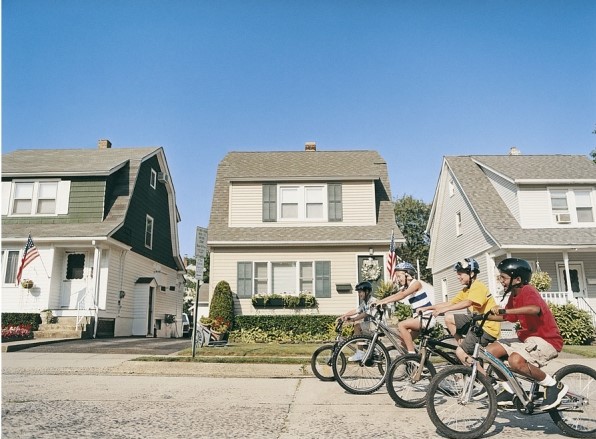 In the photo, which of the following can be seen as related to culture?   A) The bicycles. B) The house styles. C) The streets and the sidewalks. D) Broadly, all of the above are related to culture. 