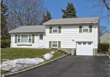 Based on the figure, a main feature of post-World War II homes not seen in earlier homes shown within this section, is   A) Bigger porches. B) More pronounced fences. C) Garages for a growing automobile culture. D) More use of the recreational space of the front yard.