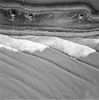 In the photograph below, notice how the waves are approaching the shore at an angle to the shoreline. This is an example of   A) wave refraction. B) swash. C) a breaker. D) backwash.