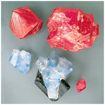 The natural samples of corundum pictured below show variations of color from red (ruby) to blue (sapphire) .The differences in color is best explained by:   A) polymerization B) crystal structure C) the principle of atomic substitution D) polymorphism