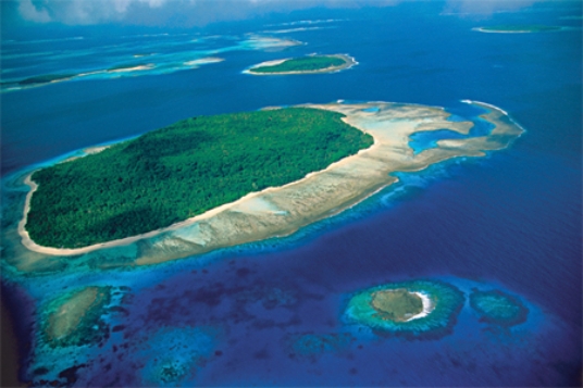 The left to right slope of the small island on the lower right of this photograph tells us that   A) a nearby stream on the mainland must be providing sediment to support the island. B) wave action must be minimal in this area. C) an area of coastal upwelling must be nearby. D) the ocean depth must be increasing to the right.