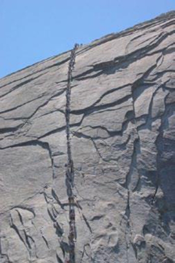 The joints in the photograph mimic topography, indicating that they formed   A) while the granite was still molten. B) while the rocks were still buried at great depth. C) when the weight of overlying rocks was unloaded, allowing expansion along the joints. D) along a subduction zone.