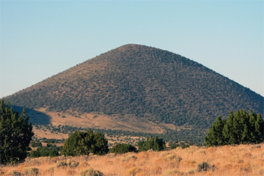 What types of rocks would be most common in the small volcano in this photograph?   A) scoria and other vesicular basalt B) basalt mostly formed in lava flows C) felsic and intermediate lava flows D) welded tuff and tephra E) None of these.