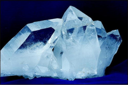 The very common mineral shown in this photograph is light colored, transparent, and fractures rather than cleaves.What mineral is it?   A) garnet B) quartz C) biotite D) muscovite E) feldspar