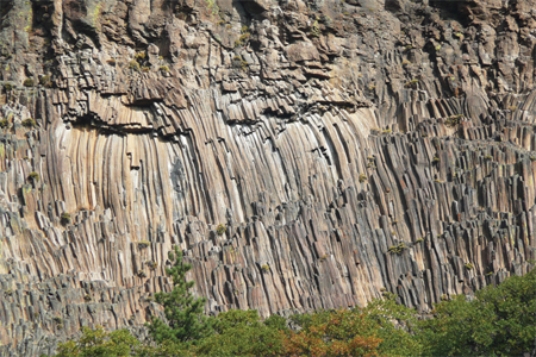 The type of feature shown in this photograph is   A) fault scarp. B) columnar joints. C) shear zone. D) folded metamorphic rocks.
