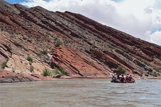 The oldest layer in this tilted sequence of sedimentary rocks is   A) at the top of the hill in the center of the photograph. B) the darkest layer. C) the layers on the lower left part of the photograph. D) the layers on the right of the photograph.