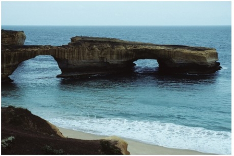 <strong>The sea cave in this photograph formed by </strong> A)erosion of a promontory by waves. B)erosion by blowing beach sand. C)removal of rocks by giant lobsters. D)a rapid drop in sea level.