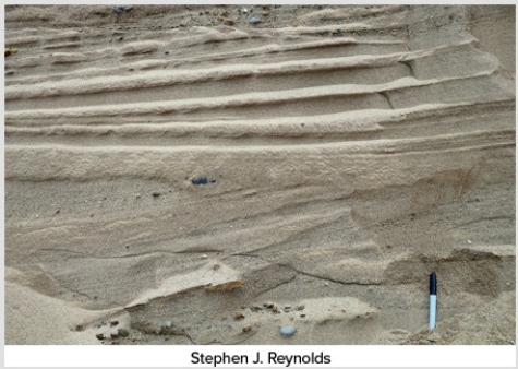 The main reason that the deposits shown here are sorted and stratified is that the glacier that dropped them was   A) moving very slowly. B) accompanied by running meltwater. C) moving through very soft,erodible bedrock. D) moving through very flat terrain.