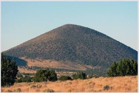 What types of rocks would be most common in the small volcano in this photograph?   A) Scoria and other vesicular basalt B) Basalt mostly formed in lava flows C) Felsic and intermediate lava flows D) Welded tuff and tephra E) None of these are correct.