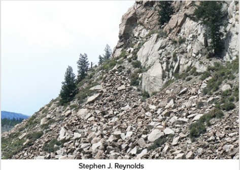 Which of the following surface environments is the most likely site for deposits in this photograph?   A) Steep mountain front B) River channel C) Sand dunes D) Beach E) Lake