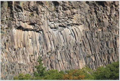 The type of feature shown in this photograph is   A) fault scarp. B) columnar joints. C) shear zone. D) folded metamorphic rocks.