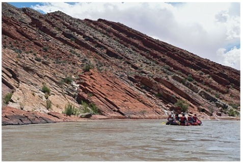 The oldest layer in this tilted sequence of sedimentary rocks is   A) at the top of the hill in the center of the photograph. B) the darkest layer. C) the layers on the lower left part of the photograph. D) the layers on the right of the photograph.