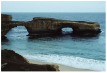 How did the sea cave in this feature form?   A) erosion of a promontory by waves B) erosion by blowing beach sand C) removal of rocks by giant lobsters D) a rapid drop in sea level