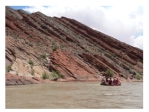 Where is the oldest layer in this tilted sequence of sedimentary rocks?   A) at the top of the hill in the center of the photograph B) the darkest layers will be the oldest C) the layers on the lower left part of the photograph D) the layers on the right of the photograph