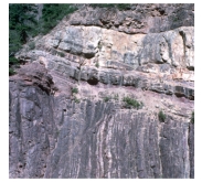 If the contact between the upper light-colored sedimentary layers and the lower dark-colored metamorphic rocks is a depositional contact,what type of feature is present?   A) a surface representing missing geologic time B) an angular unconformity C) an ancient erosion surface D) all of these