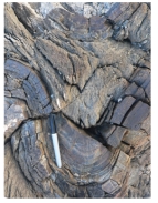 This hard rock contains sand-sized grains of quartz.Fractures cut across,not around the sand grains.What is the correct name for this rock?   A) schist B) slate C) gneiss D) quartzite