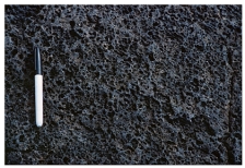 What type of basaltic feature is shown in this photograph?   A) vesicles B) volcanic bomb C) aa lava flow D) pahoehoe lava flow E) pyroclastic flow