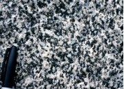 What texture is displayed by the igneous rock in this photograph?   A)  vesicles B)  breccia C)  porphyritic D)  glassy E)  none of these