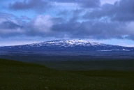 What is a main hazard of this type of volcano?   A)  hot fragments thrown a short distance from the volcano B)  burning, building collapse, and suffocation from widely distributed pyroclastic material C)  destruction by moderately fluid lava flows that can flow far from the volcano D)  volcanic mudflows and landslides E)  relatively small pyroclastic eruptions caused by localized explosions or collapse