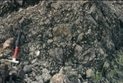 What do the characteristics of the rock in this photograph tell you about its environment?   A)  deposited by the wind B)  transported a short distance C)  transported a long distance or worked by waves D)  deposited in a lake