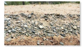 The rounded clasts in this sedimentary deposit were likely transported:   A)  by a river B)  by the wind and rounded by a rolling action during this transport C)  by a mudflow and rounded by a rolling action during this transport