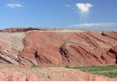 What types of features are shown in this photograph of unmetamorphosed sedimentary rocks?   A)  erosion of very tightly folded gneiss B)  erosion along joints C)  erosion of strong and weak layers D)  erosion of a series of fault scarps