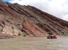 Where is the oldest layer in this tilted sequence of sedimentary rocks?   A)  at the top of the hill in the center of the photograph B)  the darkest layers will be the oldest C)  the layers on the lower left part of the photograph D)  the layers on the right of the photograph