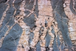 This photograph shows light-colored granite and darker diorite both igneous rocks) . Which of the following statements is true?   A)  the light-colored unit is younger because granite is more continental than diorite B)  the diorite is older because its weathered surfaces are darker C)  the granite is younger because it crosscuts the diorite D)  all of these