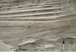 The main reason that the deposits shown here are sorted and stratified is that:   A)  the glacier that dropped them was moving very slowly. B)  the glacier that dropped them was moving quickly. C)  they were deposited by running water that accompanied the glacier.