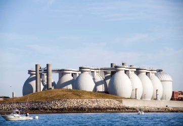   -The space inside the two buildings with the egg-shaped tops A) is filled with aerobic bacteria. B) contains large amounts of ammonia. C) is filled with biogas. D) contains high levels of oxygen.