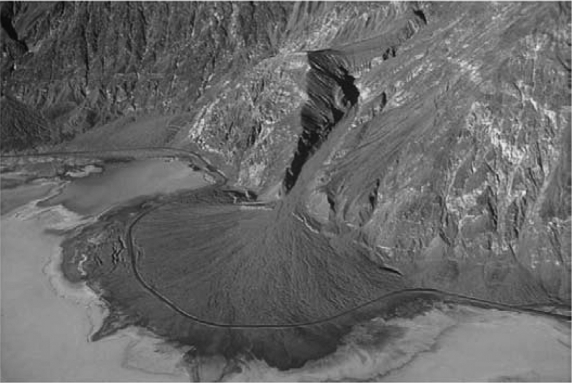 The image below of Death Valley,CA,shows a road that curves around a(n) A) delta. B) alluvial fan. C) turbidite. D) glacial till.
