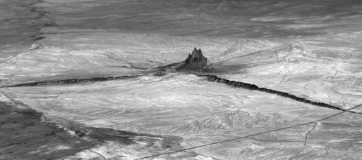 Shiprock,New Mexico,seen in the photo below is a(n)    A)  sheet-like intrusion that lies parallel to surrounding layers of sedimentary rock. B)  cooled layer of lava. C)  intrusion that represents the eroded remnant of an extinct volcano. D)  sheet-like intrusion that cuts across preexisting layers.