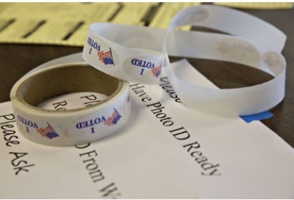    Credit: Daniel Acker/Bloomberg/Getty Images -Which of the following does this picture exemplify? A) voter incentives B) increased voter turnout C) Election Day voter registration laws -Consider This: Many new election laws have raised concerns that it may prevent certain groups from voting. D) the proliferation of voter ID laws
