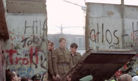    Credit: Lionel Cironneau/AP Images -How does this image symbolize the end of the Cold War? A) the Americans and the Soviets are pictured together B) the United Nations encouraged détente between superpowers C) the Berlin Wall was the symbol of a divided world D) Eastern Europeans fought off Soviet oppressors -Consider This: Many Eastern Europeans rose up and toppled Soviet-supported governments,but the fall of the Berlin Wall was a worldwide announcement that the Cold War was coming to an end.