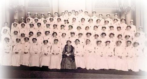   -What does this graduation photograph of the Philadelphia School for Nurses, which includes Red Cross founder Clara Barton in the center, imply about the nursing profession in 1900? A)  Women had become leaders in the workforce. B)  Nursing had emerged as a respected profession. C)  Nurses had the right and power to strike against oppressive working conditions. D)  Nursing was an ethnically diverse career in the United States.