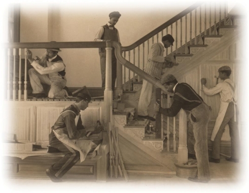   -How does this photograph of a carpentering class at the Hampton Institute reflect Booker T. Washington's ideas of how African Americans should achieve success? A)  It fosters an image of African Americans as superior craftsmen. B)  It calms the fears of white supremacists by showing blacks working menial jobs. C)  It shows young men working at a trade school to gain skills necessary for advancement. D)  It shows young men silently demonstrating their fitness to attend a desegregated school.
