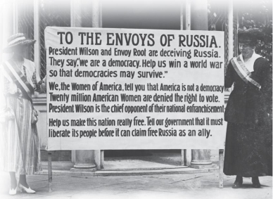   -What is the underlying view of democracy expressed by the militant suffragists in this image? A)  In a true democracy, the right to vote is extended to all. B)  Capitalism and democracy cannot truly co-exist. C)  Waging war is not the proper way to defend democracy. D)  Democracies can be allies only with other democracies.